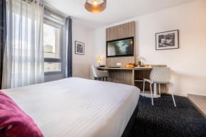 ナンシーにあるNemea Appart Hotel Grand Cœur Nancy Centreのベッドとデスクが備わるホテルルームです。