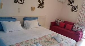 1 dormitorio con 1 cama y 1 sofá rojo en Villa Nefeli Skiathos, en Skiathos