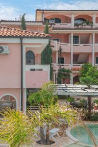 a pink building with a pool in front of it at Casa Selimi in Ulcinj