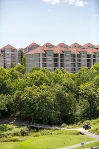 een appartementencomplex op de achtergrond met bomen en een golfbaan bij Grand Crowne Resort in Branson