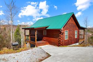 une petite cabane en rondins avec un toit vert dans l'établissement Cabin In The Smokeys, à Gatlinburg