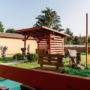 een kleine houten hut met een bank in een tuin bij PICNIC Vendégház in Bogács