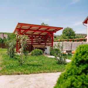 een rood paviljoen in een tuin met een gebouw bij PICNIC Vendégház in Bogács