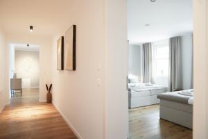 biały apartament z białymi ścianami i drewnianą podłogą w obiekcie LaMiaCasa City 110qm Balkon & Garage Stylish Living w Tybindze