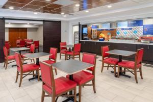 uma sala de jantar com mesas e cadeiras vermelhas em Holiday Inn Express & Suites Colorado Springs-Airport by IHG em Colorado Springs