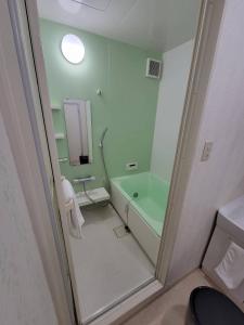 bagno con vasca verde e lavandino di P-STAY広島平和公園withペット 401号室 a Hiroshima