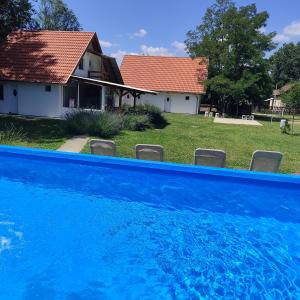 una piscina blu di fronte a una casa di Mirella rooms a Palić