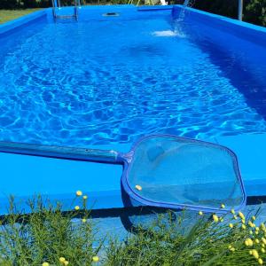 una piscina blu con un contenitore blu di Mirella rooms a Palić