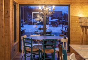 ein Esszimmer mit einem Tisch, Stühlen und einem Fenster in der Unterkunft Orso Bianco Hotel & Chalet in Sauze dʼOulx