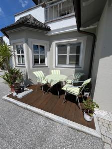 um deque de madeira com uma mesa e cadeiras em frente a uma casa em Apartment Kerer em Wald im Pinzgau