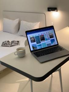 a laptop computer sitting on a desk next to a bed at Ultramarinn Hotel in Odesa