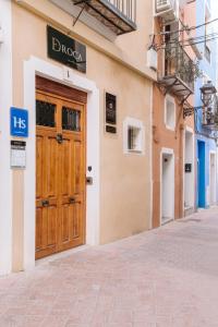 un edificio con una porta in legno su una strada di Pou by Seaward Suites Only Adults a Villajoyosa