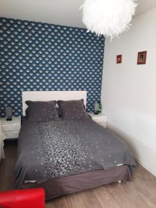 um quarto com uma cama e uma parede azul e branca em la conviviale em Bénouville