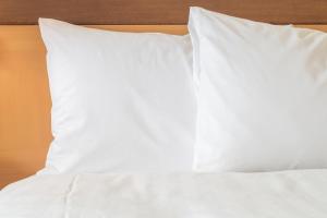 een bed met witte lakens en kussens erop bij Holiday Inn Express & Suites Austin Airport East, an IHG Hotel in Austin