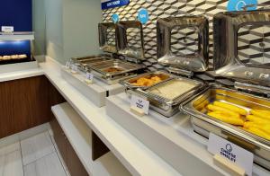 een buffetlijn met dienbladen eten bij Holiday Inn Express & Suites Austin Airport East, an IHG Hotel in Austin