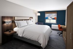 een slaapkamer met een groot wit bed en een bureau bij Holiday Inn Express & Suites Austin Airport East, an IHG Hotel in Austin