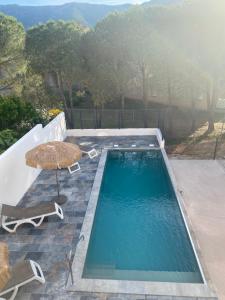 uma piscina com uma mesa e um guarda-sol em Résidence Beausoleil em Galeria