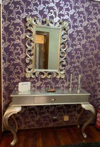 a bathroom with a mirror on a purple wall at Apartamento El Rincón de Pilar in El Astillero