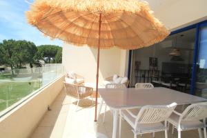 een tafel en stoelen met een parasol op een balkon bij Aldeamento Bemposta - Pool & Garden Bemposta in Alvor