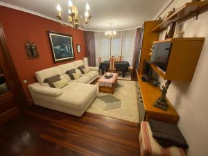 a living room with a white couch and a table at Apartamento El Rincón de Pilar in El Astillero