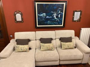 a white couch in a living room with a painting at Apartamento El Rincón de Pilar in El Astillero