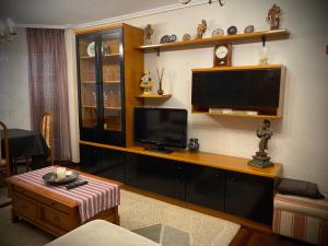 a living room with a flat screen tv and a table at Apartamento El Rincón de Pilar in El Astillero