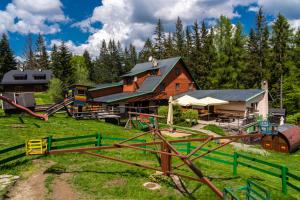 ein Holzhaus mit einem Spielplatz auf dem Feld in der Unterkunft Bačkárka - horská chata in Makov