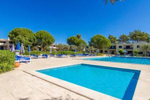 een zwembad met stoelen en parasols in een resort bij Aldeamento Bemposta - Pool & Garden Bemposta in Alvor