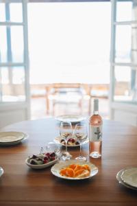 uma mesa com pratos de comida e uma garrafa de vinho em Villa Il Paradiso Andros em Gavrio