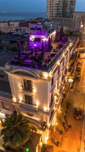 een groot wit gebouw met verlichting in een stadsstraat bij Envy Hotel in Durrës