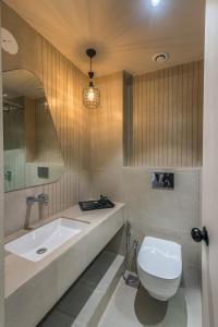 bagno con servizi igienici bianchi e lavandino di Wabi Sabi Resort, Igatpuri a Igatpuri