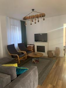 ein Wohnzimmer mit einem Sofa und einem TV in der Unterkunft Casa Mai in Vişeu de Sus