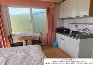 uma cozinha com um lavatório e uma mesa com cadeiras em Seaside Minbak em Goseong