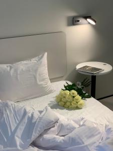 a bed with a bouquet of flowers on it at Ultramarinn Hotel in Odesa