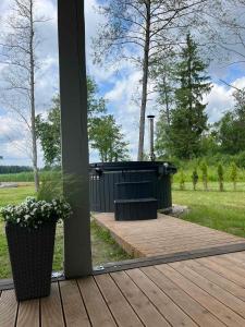 a porch with a bench on a wooden deck at Namelis ant ežero kranto "Giliaus Elingas" in Tytuvėnai