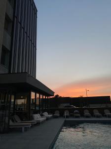 a pool with chairs and a sunset in the background at Adonis le Castellet in Signes