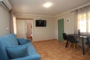 a living room with a blue couch and a table at Olga Home Agios Ioannis Lefkada - Lefkada BnB in Lefkada Town