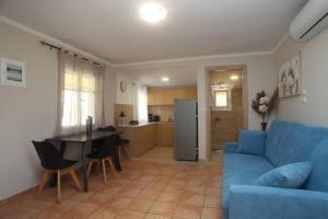 a living room with a blue couch and a table at Olga Home Agios Ioannis Lefkada - Lefkada BnB in Lefkada Town