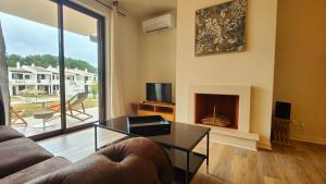 a living room with a couch and a fireplace at Apartamento com terraços privativos em resort de luxo in Alvor