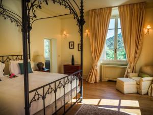 ein Schlafzimmer mit einem Himmelbett und einem Sofa in der Unterkunft Hotel Villa Casanova in Lucca