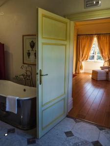 ein Bad mit einer Badewanne neben einer Tür in der Unterkunft Hotel Villa Casanova in Lucca