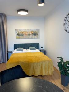 - une chambre avec un lit et une couverture jaune dans l'établissement H52 Apartments, à Brno