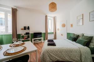 um quarto verde e branco com uma cama e um sofá em Le Studio Saint-Pierre - Dax em Dax