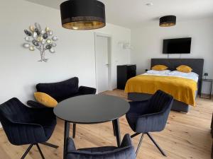 - une chambre avec un lit, une table et des chaises dans l'établissement H52 Apartments, à Brno