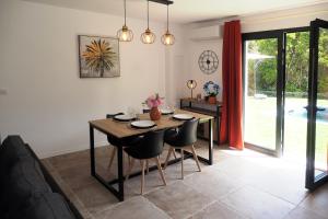 a dining room with a wooden table and chairs at Casa Solana - Piscine privée et chauffée in Galeria