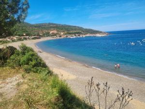 a beach with people swimming in the water at Casa Solana - Piscine privée et chauffée in Galeria