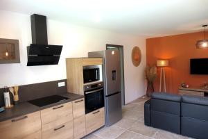 a kitchen with a stainless steel refrigerator and a couch at Casa Solana - Piscine privée et chauffée in Galeria