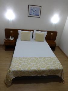 a bedroom with a large white bed with two tables at Hotel Sinagoga in Tomar