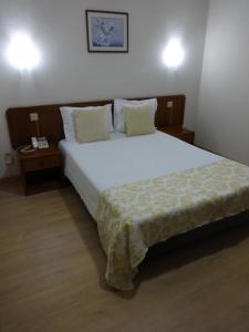 a bedroom with a large white bed with two pillows at Hotel Sinagoga in Tomar