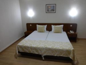 a bedroom with a large bed with white sheets and pillows at Hotel Sinagoga in Tomar